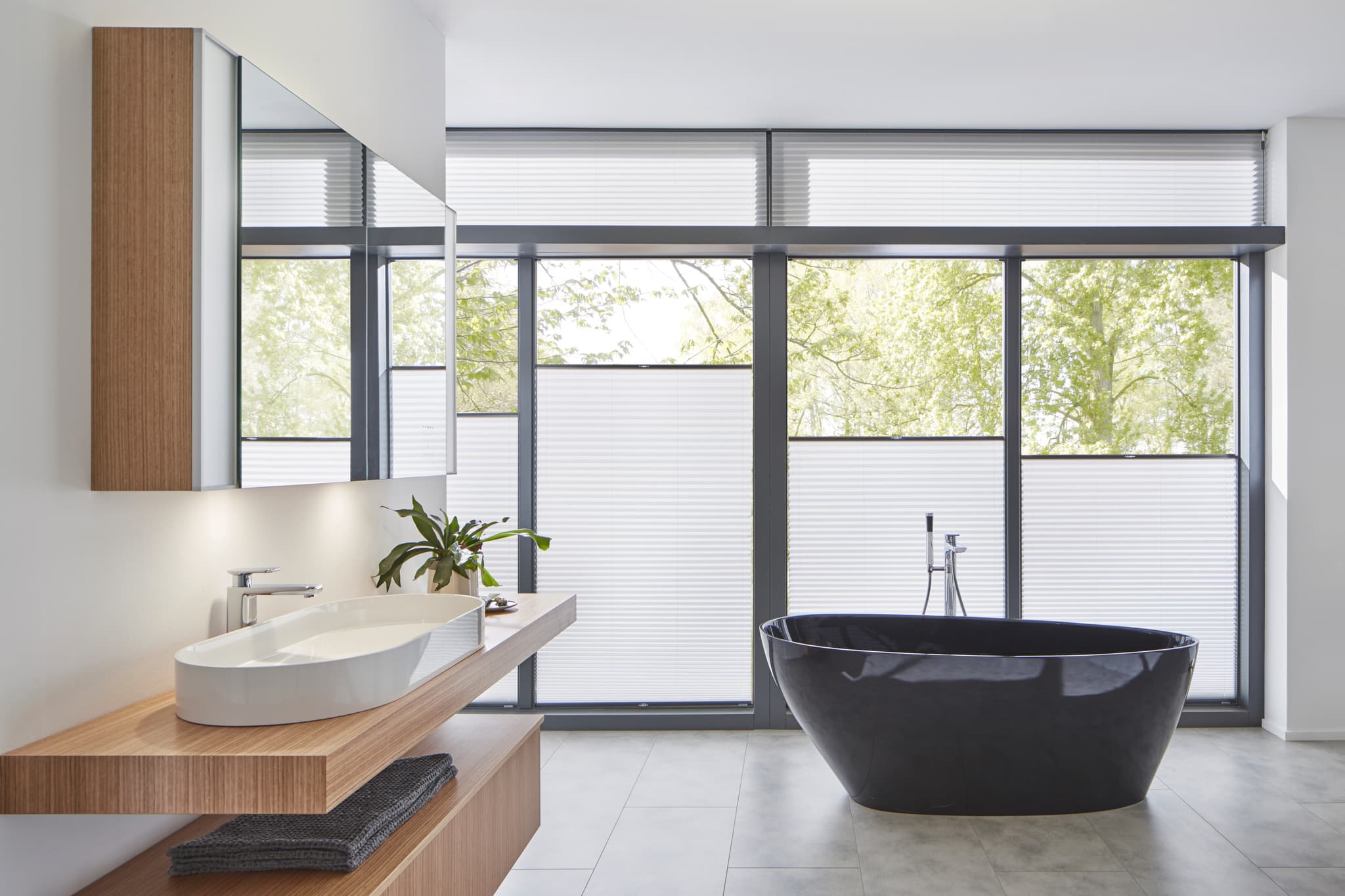 Modernes Badezimmer mit Plissee an grossen Fensterfronten